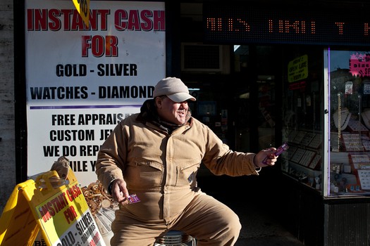 A man handing cards for a jewelry exchange shop on Broad Street.